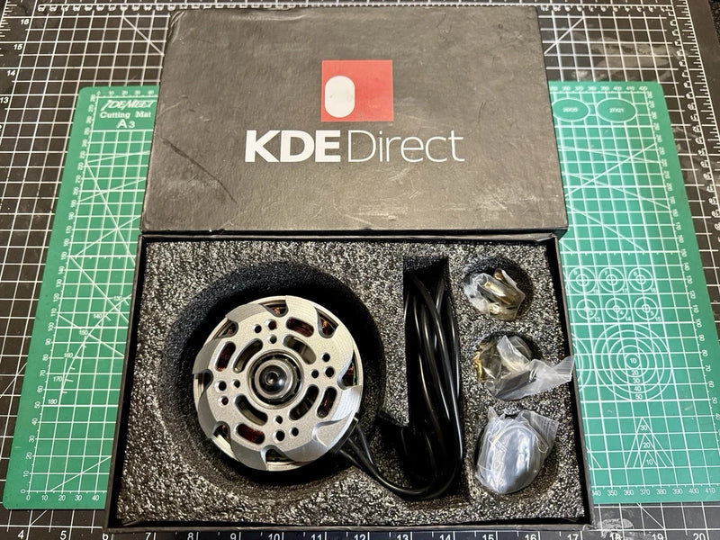 Brushless DC motor with silver circular stator and black wire leads in box