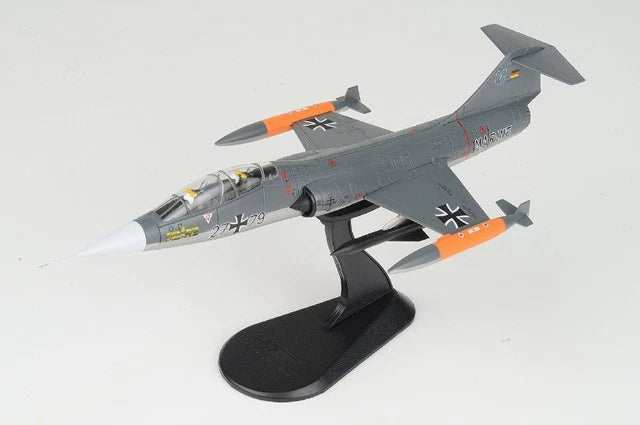 Gray and orange jet aircraft model on black display stand, detailed nose and wings
