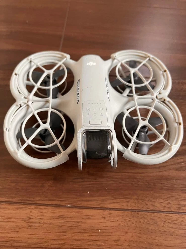 DJI quadcopter drone with four white propellers and front sensor module
