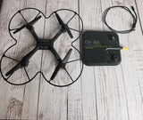 Black video drone with four propellers and matching black remote controller