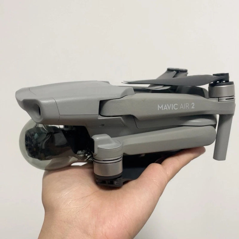 Gray DJI Mavic Air 2 drone with folded propeller arms, held in a hand