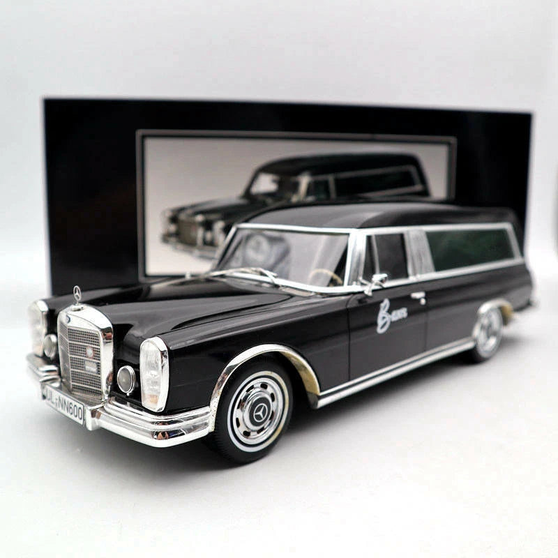 Die-cast toy hearse model car, black with silver grille, bumper, and whitewall wheels