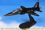 Black 1:72 model fighter jet on display stand, nose pointing left with tail number