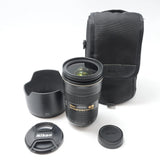 Nikon 24-70mm f/2.8 camera lens with lens hood, caps, and black carrying case