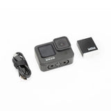 GoPro HERO9 Black action camera with USB cable and power adapter, front view