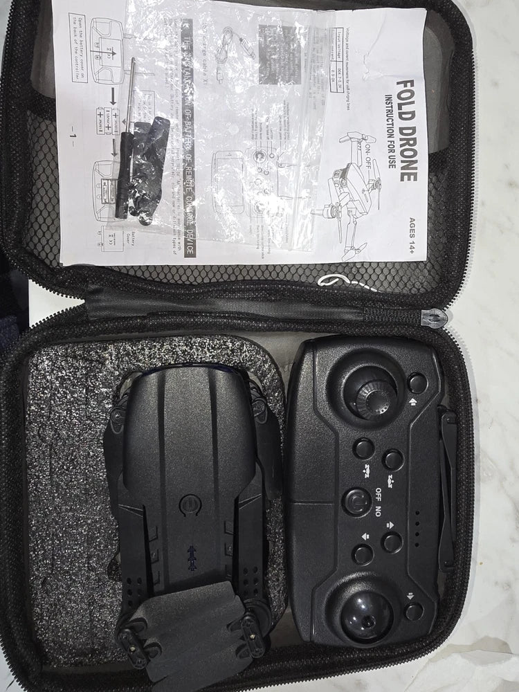 Black folding FPV camera drone with controller and charging accessories in case