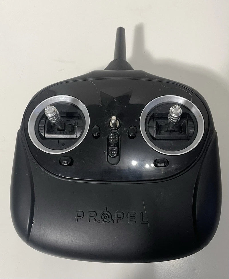 Propel drone remote control, black handheld with two joysticks and center button, front view