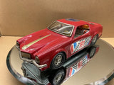 Vintage battery-operated toy model car, red with racing decals and stripes, 3/4 front view