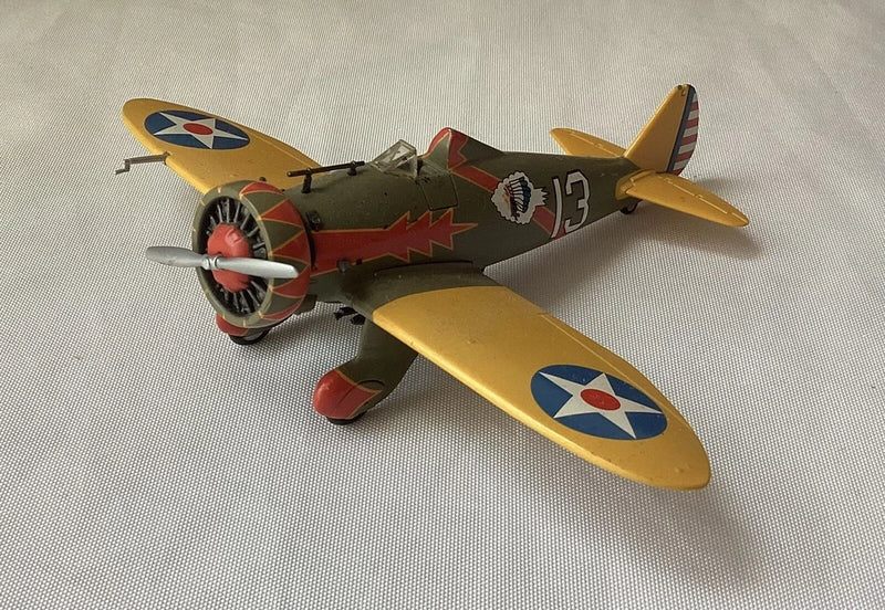 Toy model airplane with yellow wings, red nose, and propeller, U.S. Army style markings