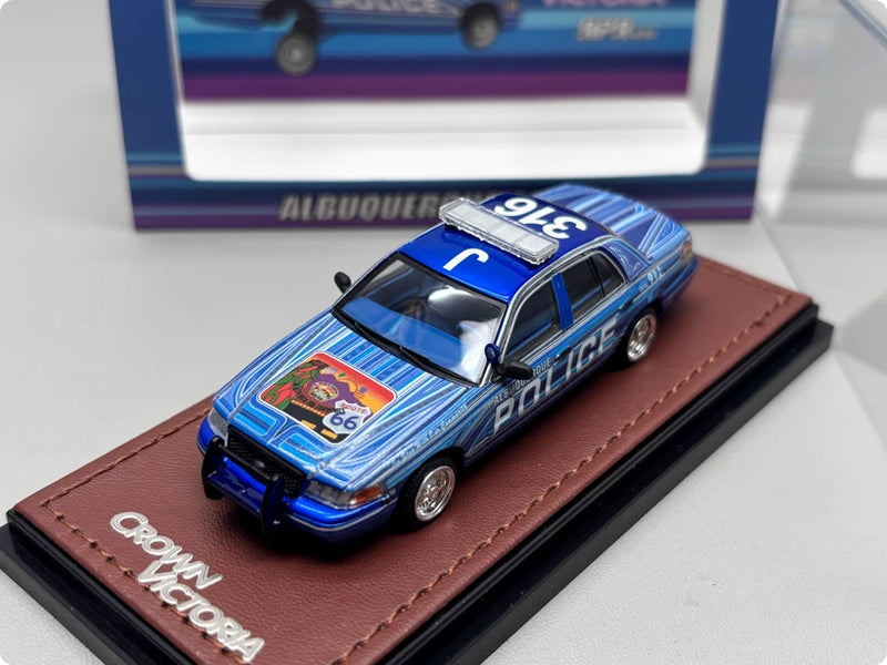 Blue police car alloy model with "Police" decals, on display base with Crown Victoria logo