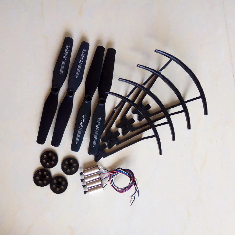 RC drone spare parts set: black propellers, blade guards, and metal motor housings
