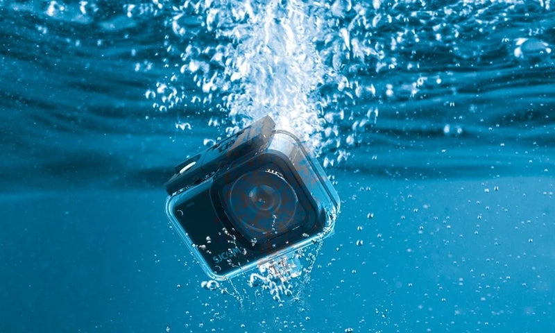 Waterproof underwater action camera in case floating underwater, front screen visible