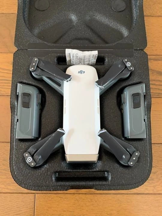 Compact quadcopter drone with four prop arms in a padded case