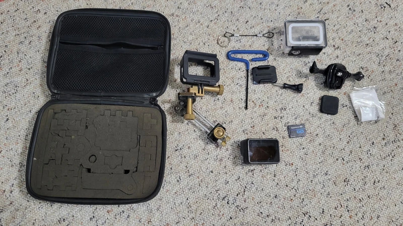 GoPro Hero action camera kit with open case, mounting clip, and accessory pieces