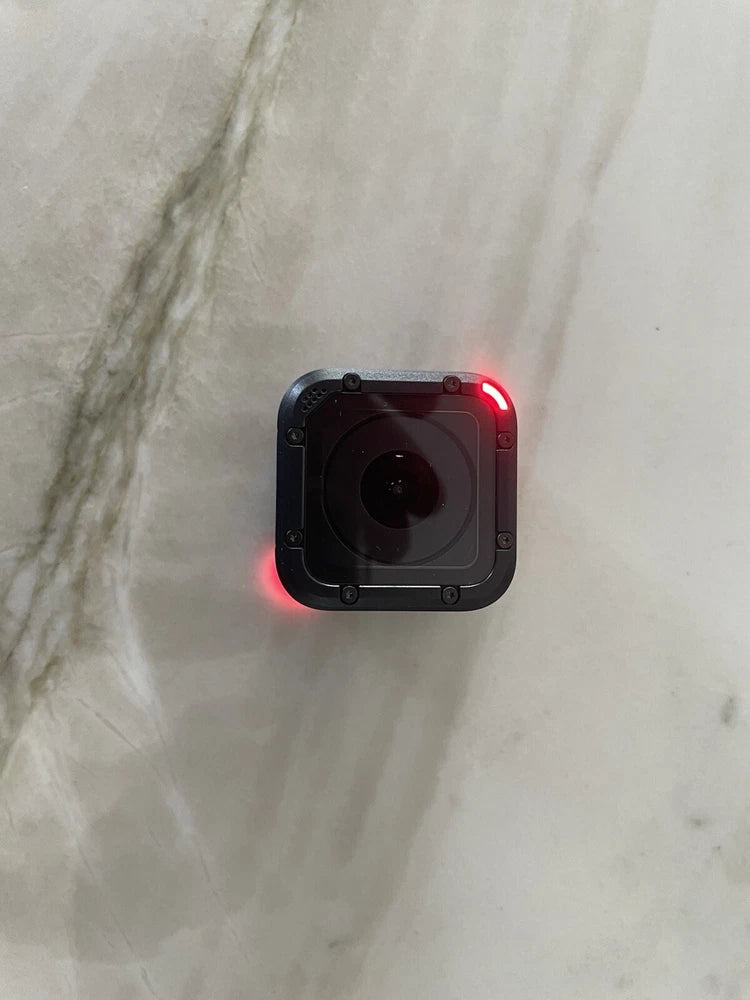 Black action sports camera with front lens and red status light on rear frame