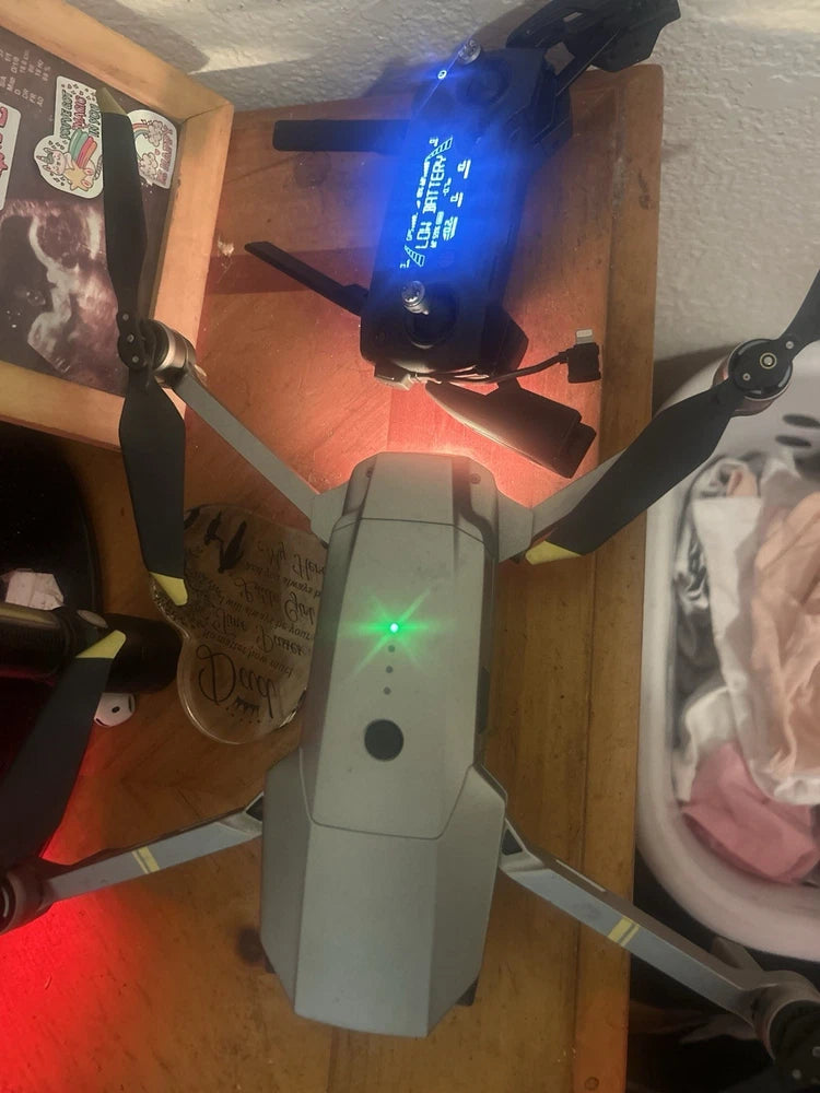 Gray quadcopter drone with illuminated lights and four propellers