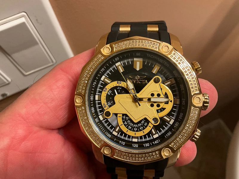 INVICTA diver watch with gold-tone case, black dial, rhinestone bezel, and black strap