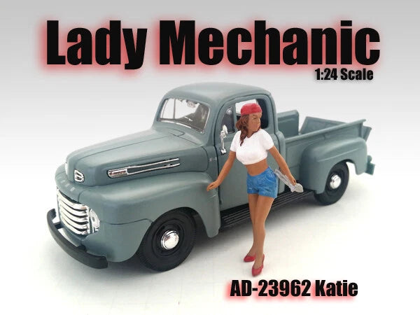 1/24 scale lady mechanic figurine in white top and denim shorts beside blue pickup