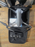 Gray quadcopter drone with controller in hard carrying case