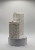 Miniature white tower building model with detailed facade on round gray base