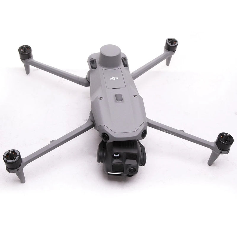 Gray quadcopter drone with four propellers and center camera housing