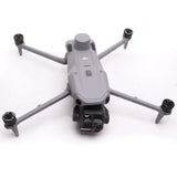 Gray quadcopter drone with four propellers and center camera housing
