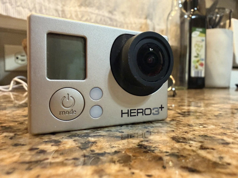 Silver and black action camera with LCD screen, mode buttons, and HERO3+ lens